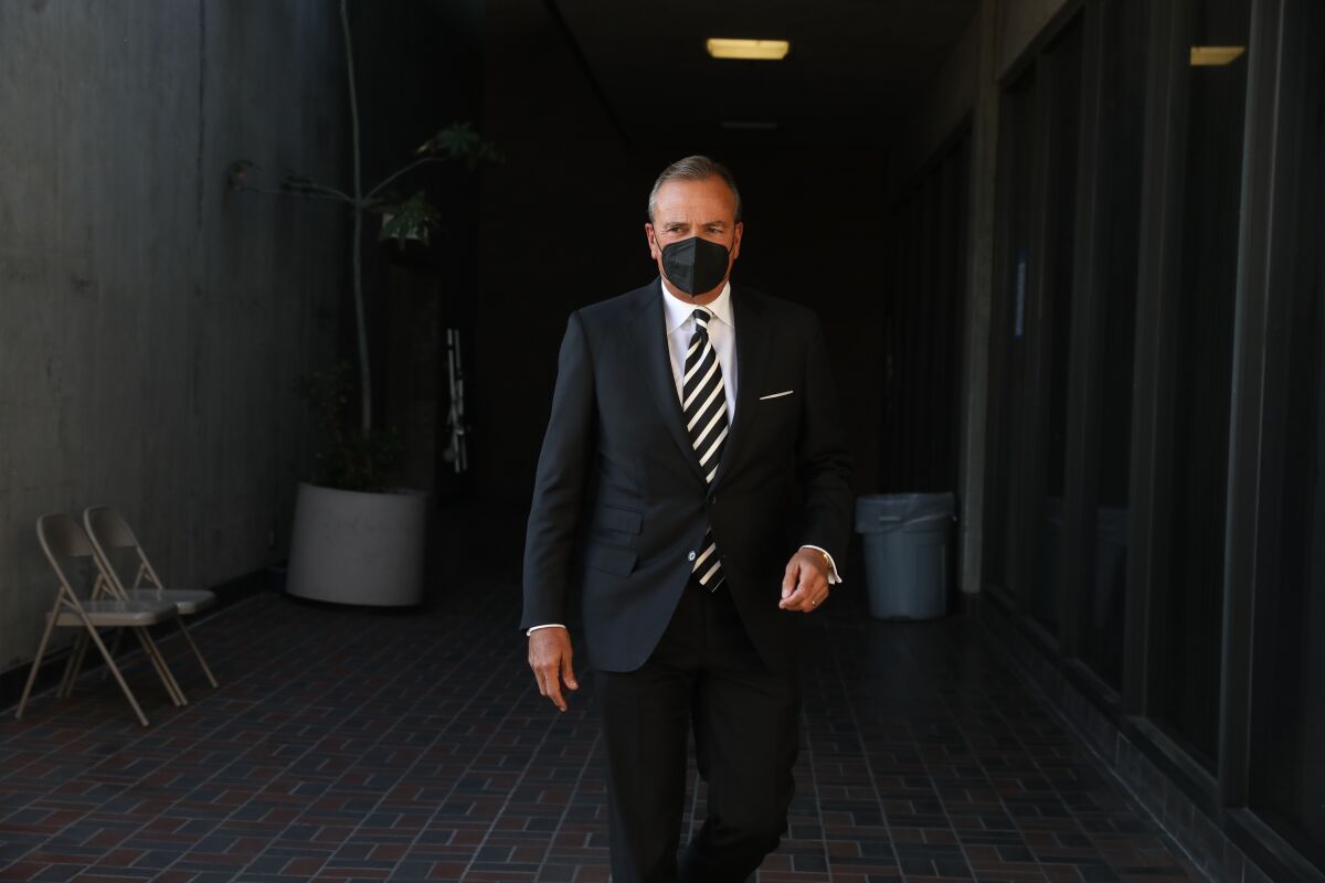 Rick Caruso in a suit and a mask