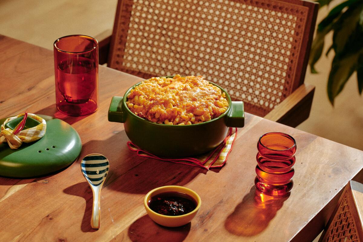 A heaping round casserole of macaroni and cheese on a wooden table.