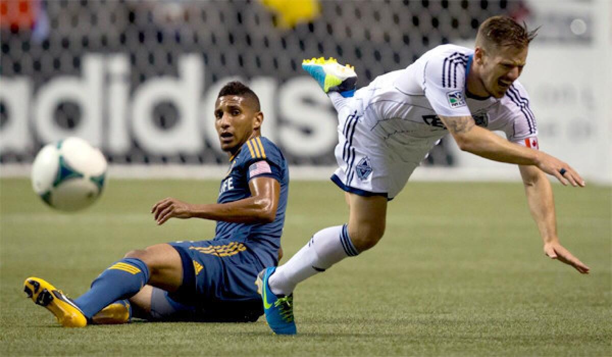 The Galaxy's Sean Franklin trips Vancouver's Jordan Harvey during L.A.'s 1-0 win over the Whitecaps on Aug. 24.