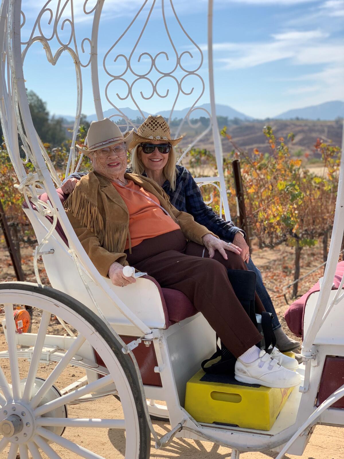 Opal Hagerty, left, rides in the carriage with Judy Lucous, wellness director at Cypress Court retirement community in Escondido. Through the community's Dreams Do Come True program, Lucous grants bucket-list wishes for the center elderly residents.