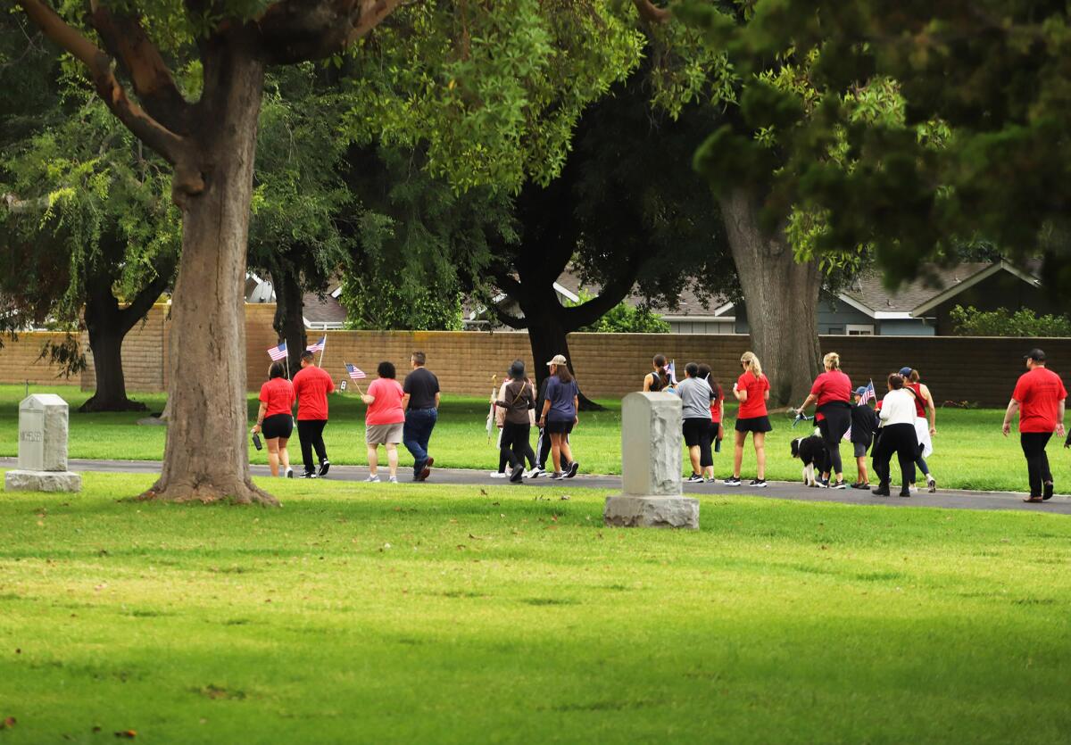People walk 2,200 steps around FairHaven Memorial Park in Santa Ana Sunday to honor 9/11 first responders. 