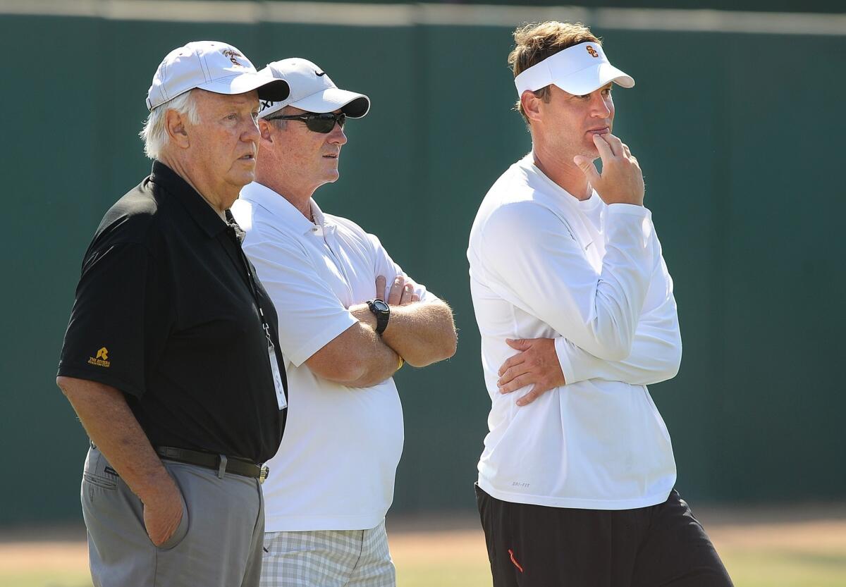 Former college coaches John Robinson, left, and Jeff Tedford, center, watch practice with USC head coach Lane Kiffin at USC.