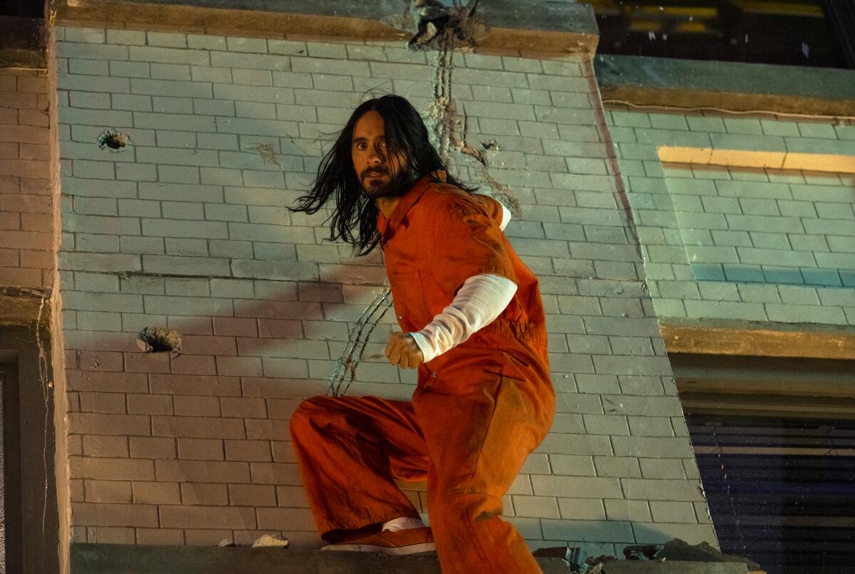A beareded Jared Leto in an orange jumpsuit in the movie “Morbius.”