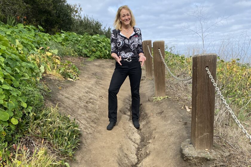 Friends of Coast Walk Trail founder Brenda Fake points out the most eroded part of the path in La Jolla.