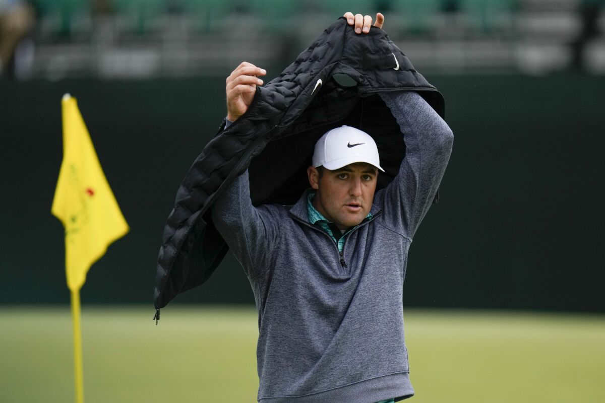 Scottie Scheffler puts on a vest on the fifth hole during the third round at the Masters golf tournament on Saturday, April 9, 2022, in Augusta, Ga. (AP Photo/Jae C. Hong)