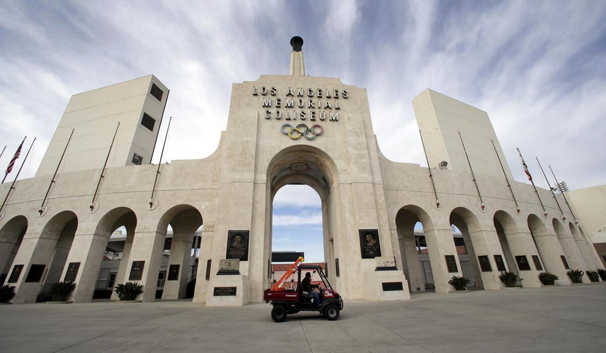 A worker rides past the entrance of the Los Angeles Memorial Coliseum on Jan. 13.