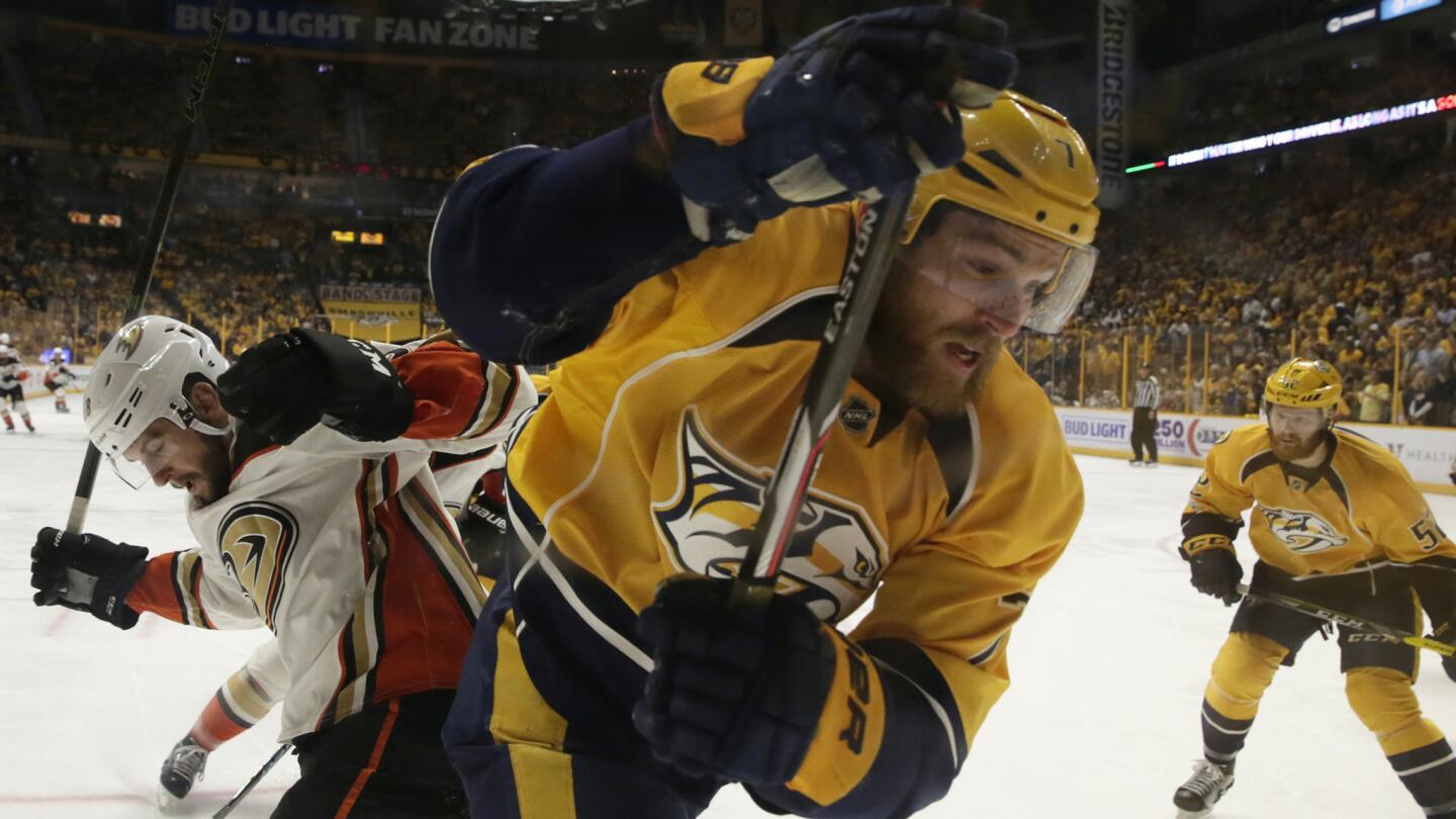 Ducks forward Nicolas Kerdiles checks Predators defenseman Yannick Weber into the boards during the first period.