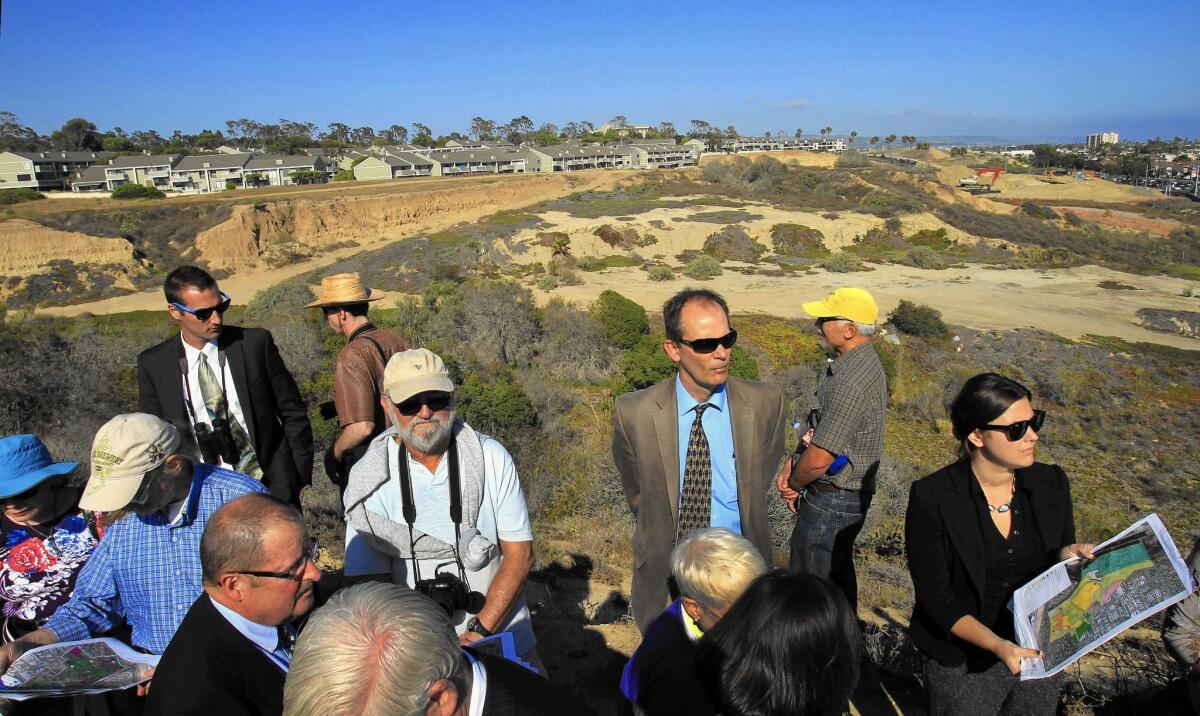 Charles Lester, executive director of the California Coastal Commission, center in suit and tie, tours a project near Newport Beach. News broke last week that some commissioners are angling to oust him from his position.