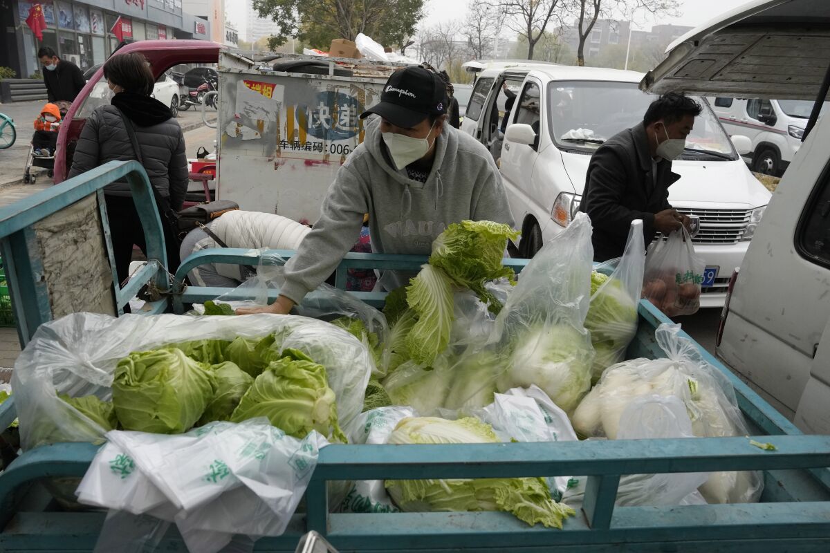 Shoppers buying fresh vegetables from street vendors
