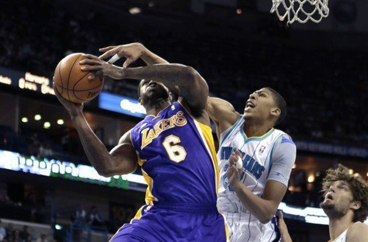 Hornets power forward Anthony Davis tries to block a shot by Lakers forward Earl Clark in the first half Wednesday night in New Orleans.