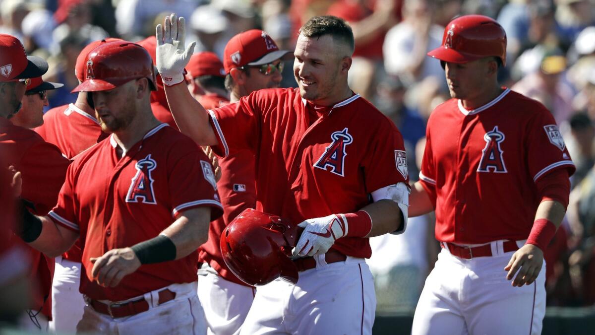 Mike Trout is congratulated by his Angels teammates after hitting a three-run home run against the Chicago Cubs on March 5.