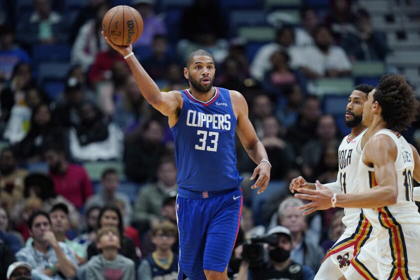LA Clippers forward Nicolas Batum (33) passes around New Orleans Pelicans forward Garrett Temple and center Jaxson Hayes (10) in the first half of an NBA basketball game in New Orleans, Friday, Nov. 19, 2021. (AP Photo/Gerald Herbert)