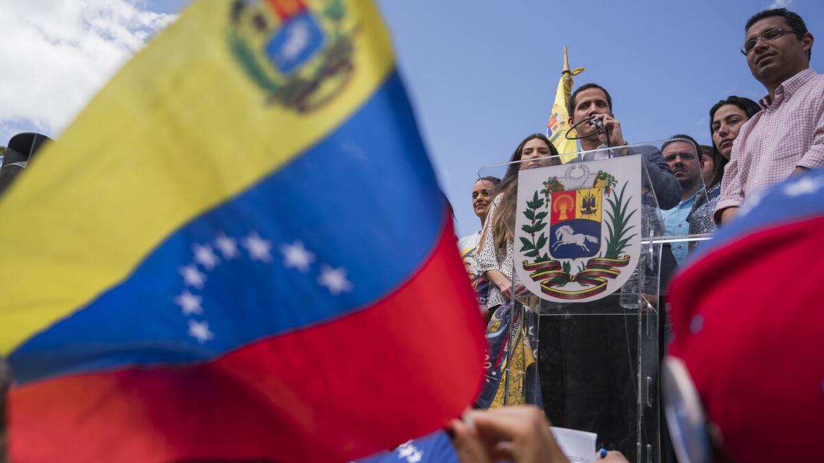 Venezuela's self-declared interim leader Juan Guaido, center, speaks to supporters at a rally at a plaza in Caracas on Saturday.
