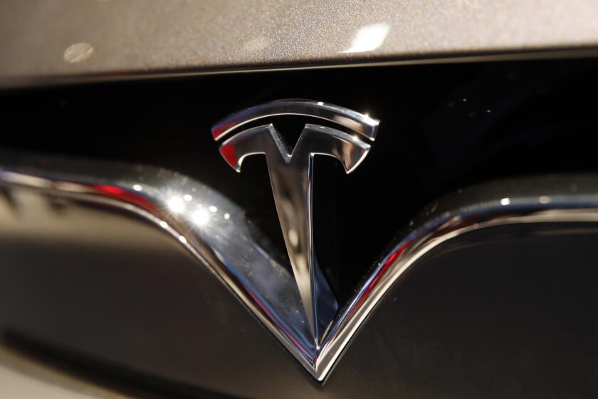 The logo of Tesla is pictured at the Auto show in Paris, France, Wednesday, Oct. 3, 2018, 2018. All-electric vehicles with zero local emissions are among the stars of the Paris auto show, rubbing shoulders with the fossil-fuel burning SUVs that many car buyers love. (AP Photo/Christophe Ena)
