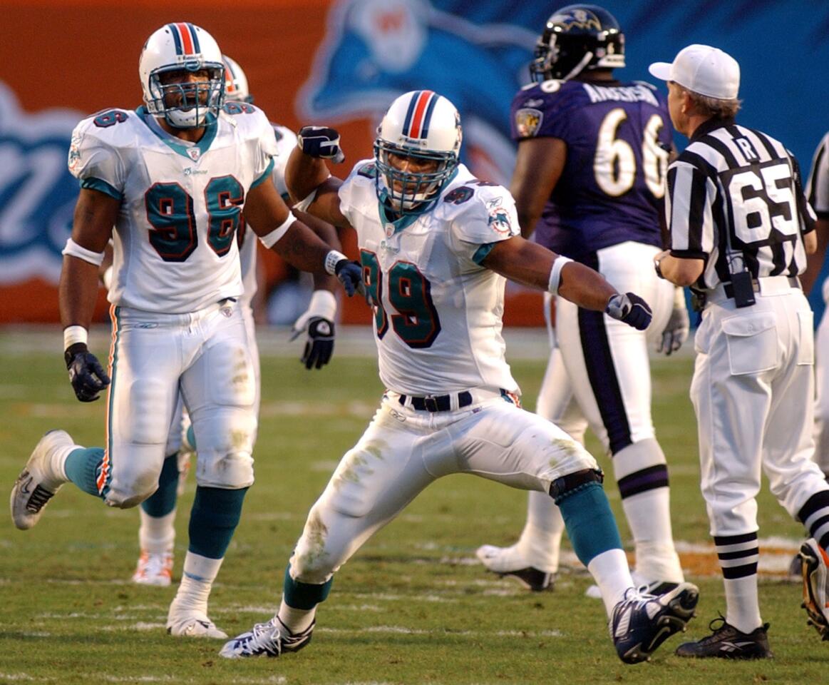 Miami Dolphins defensive end Jason Taylor, center, celebrates a hit on Baltimore Ravens' quarterback Jeff Blake which resulted in an incomplete pass during the second quarter Sunday, Nov. 17, 2002 in Miami. (AP Photo/Rick Silva) ORG XMIT: PPS105