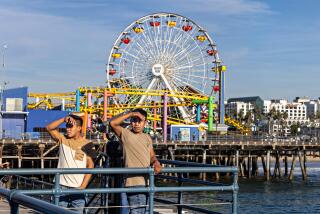 Santa Monica, CA - December 04: People enjoy a day at the Santa Monica Pier during the first week of December on Monday, Dec. 4, 2023 in Santa Monica, CA. (Jason Armond / Los Angeles Times)