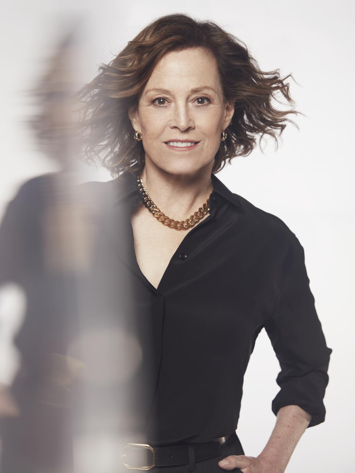 Sigourney Weaver smiles into the camera in a double-exposure portrait.