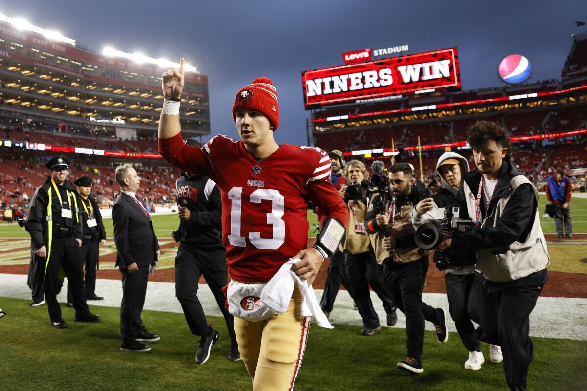 San Francisco 49ers quarterback Brock Purdy holds up a finger in celebration.