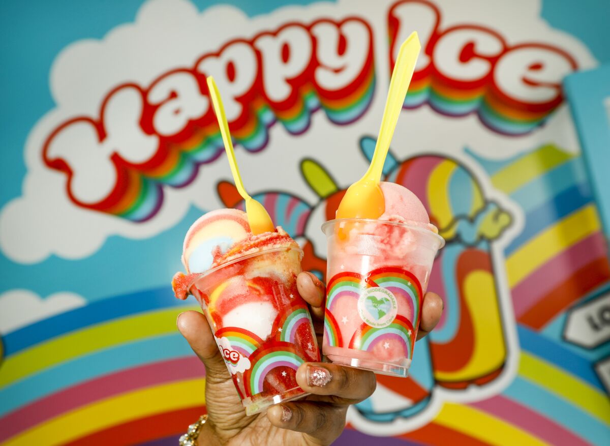 Photo of a hand holding two colorful Philadelphia-style water ices from Happy Ice.