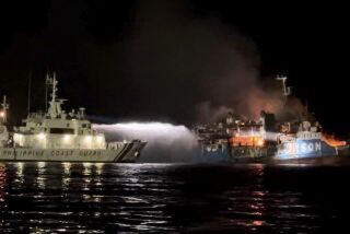 En esta imagen difundida por la Guardia Costera de Filipinas, un barco de la Guardia Costera de Filipinas intenta apagar un incendio en el MV Lady Mary Joy, el jueves 30 de marzo de 2023, en Basilán, Filipinas. (Guardia Costera de Filipinas via AP)
