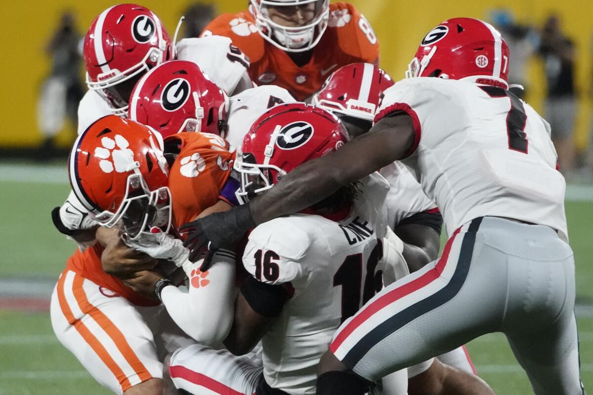 Clemson quarterback D.J. Uiagalelei is tackled by several Georgia defensive players Sept. 4, 2021.