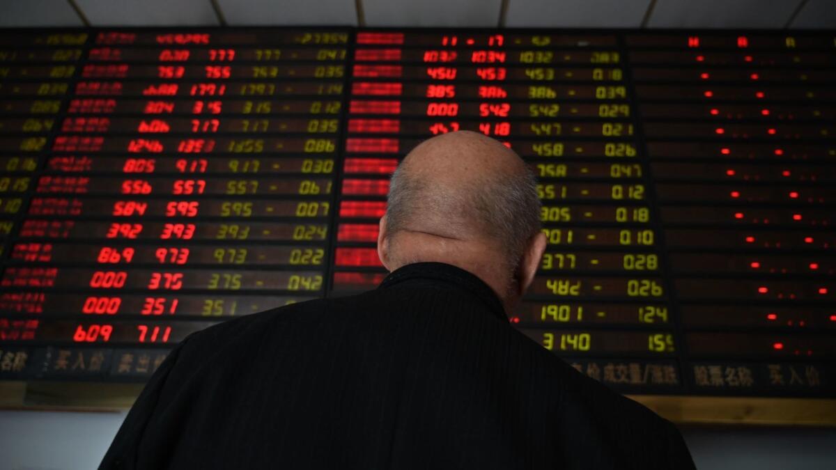 Investors monitor stock price movements at a securities company in Shanghai on Monday.