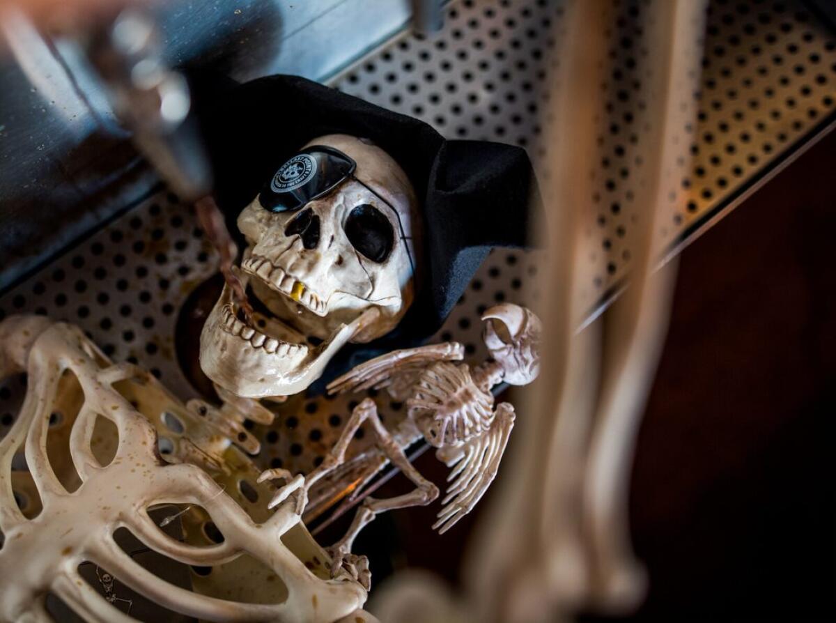 A skeleton drinks from a tap at a Ballast Point tasting room during a Victory at Sea Day celebration