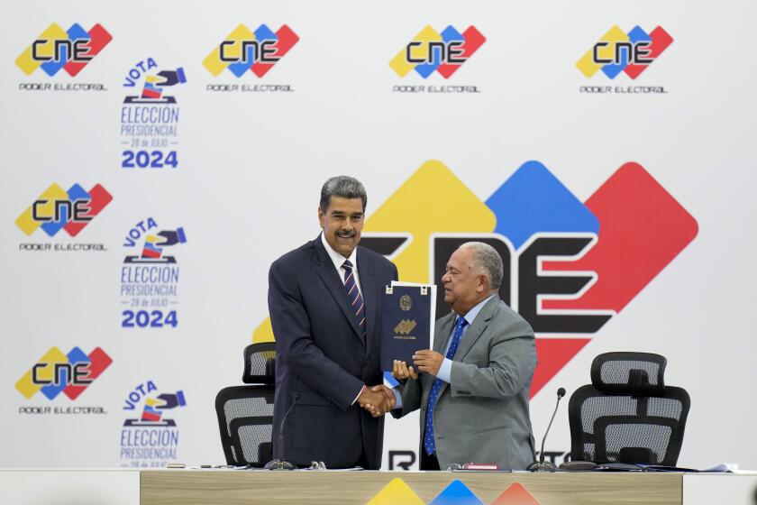 El presidente venezolano Nicolás Maduro, a la izquierda, recibe la certificación del presidente del Consejo Nacional Electoral (CNE), Elvis Amoroso, de que ganó las elecciones presidenciales en Caracas, Venezuela, el lunes 29 de julio de 2024. (AP Foto/Matías Delacroix)