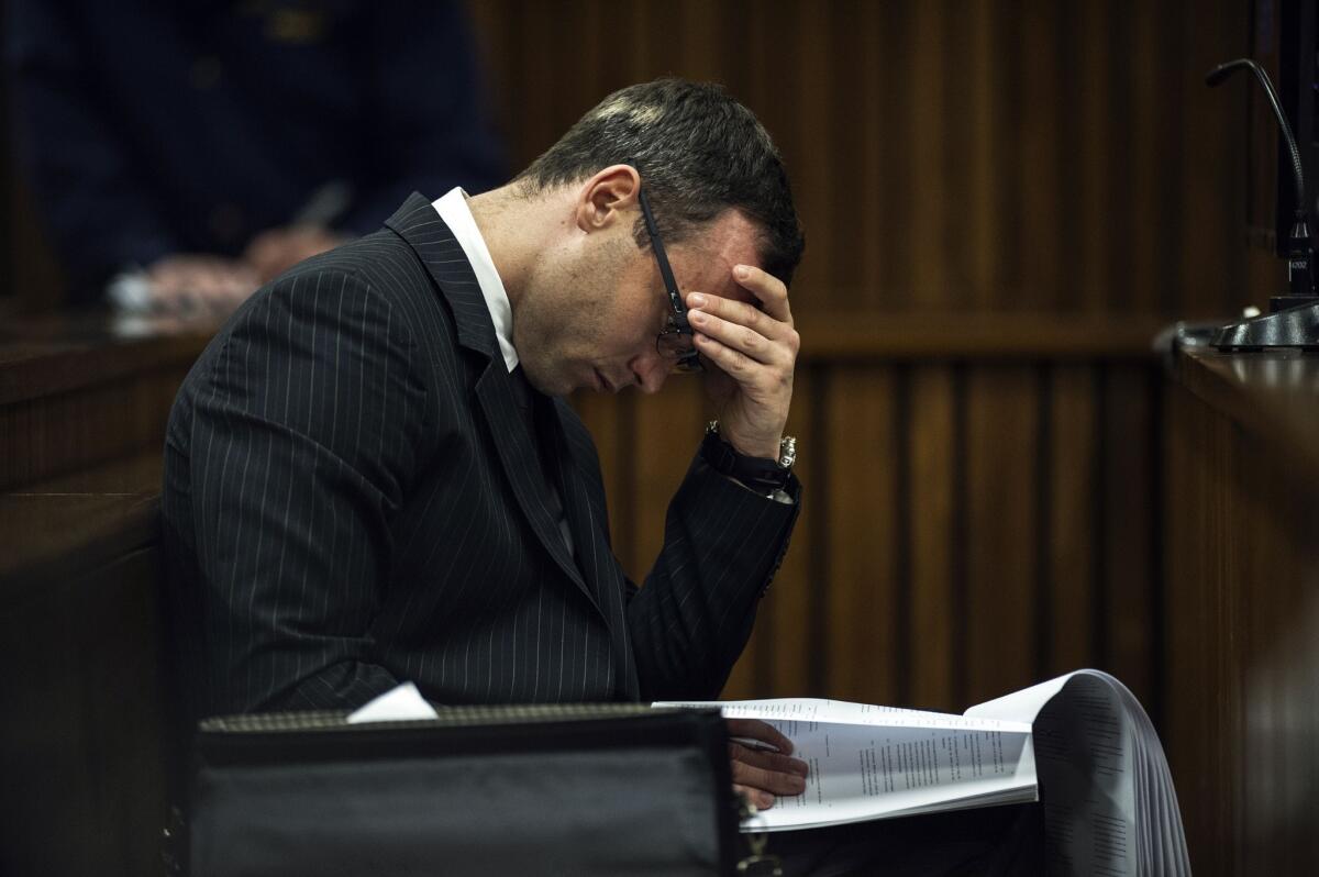 South African Olympian Oscar Pistorius reads in court on July 2.