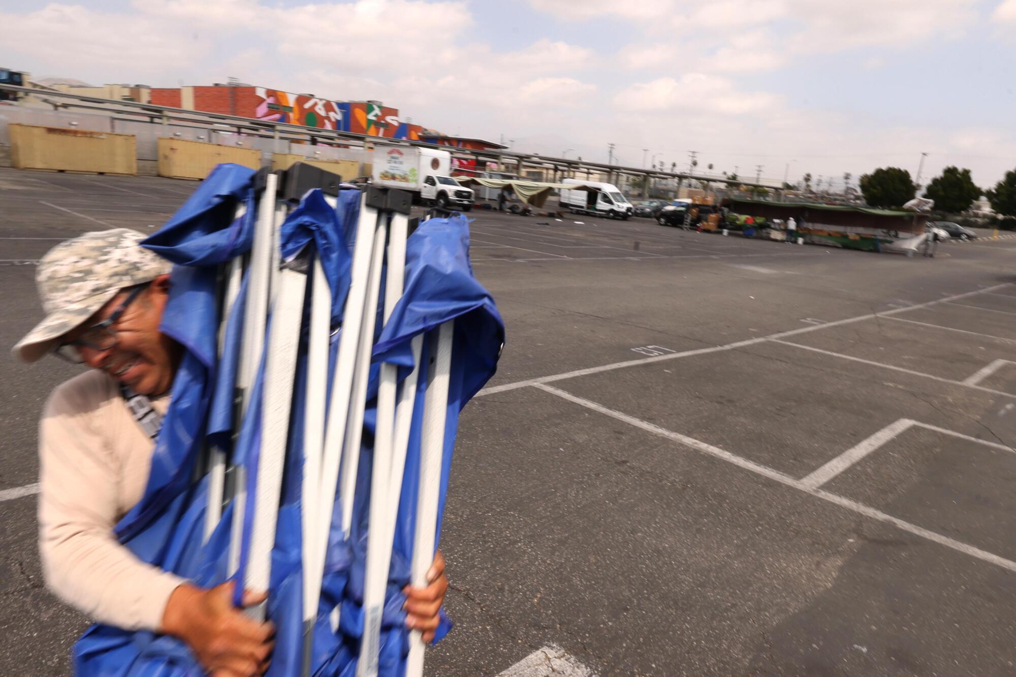 Vendor Richard Gomez, 53, packs up his tent after a slow day of selling his wares at the San Fernando Swap Meet.