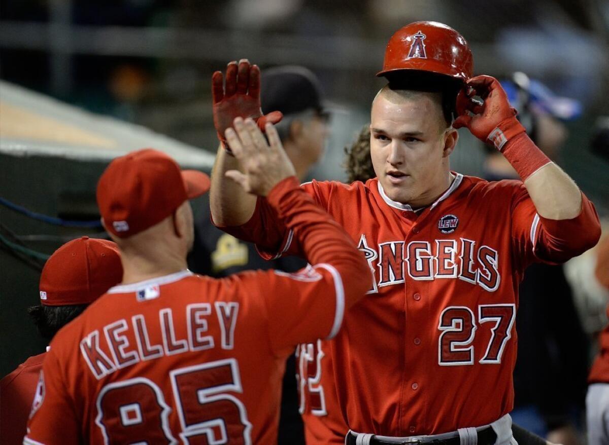 Mike Trout is congratulated by his Angels teammates after he scored on a bases loaded two-run single on Sept. 16.