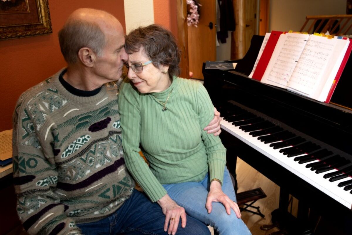Skagit Valley Chorale members Mark Backlund and his wife, Ruth, embrace in their Anacortes, Wash., home March 27 during their convalescence from COVID-19, which claimed the lives of two fellow choir members within days of a rehearsal.