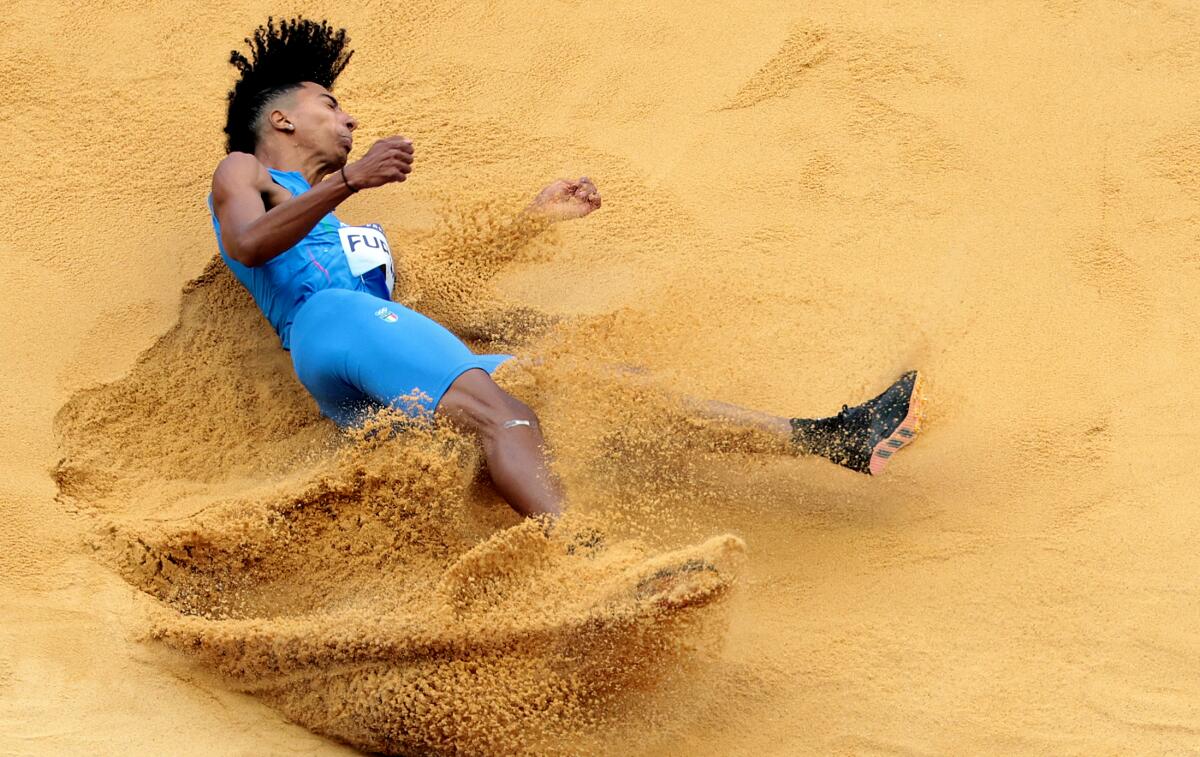 Italy's Matt Furlani lands in the sand pit during men's long jump qualifying.