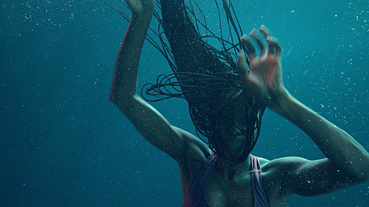 A woman underwater, her braids floating above her in the movie "Nanny."
