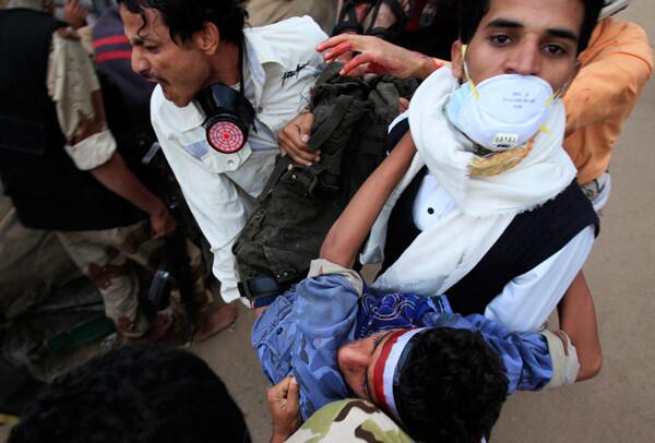 Anti-government protesters carry an injured protester during clashes with police in Sanaa.