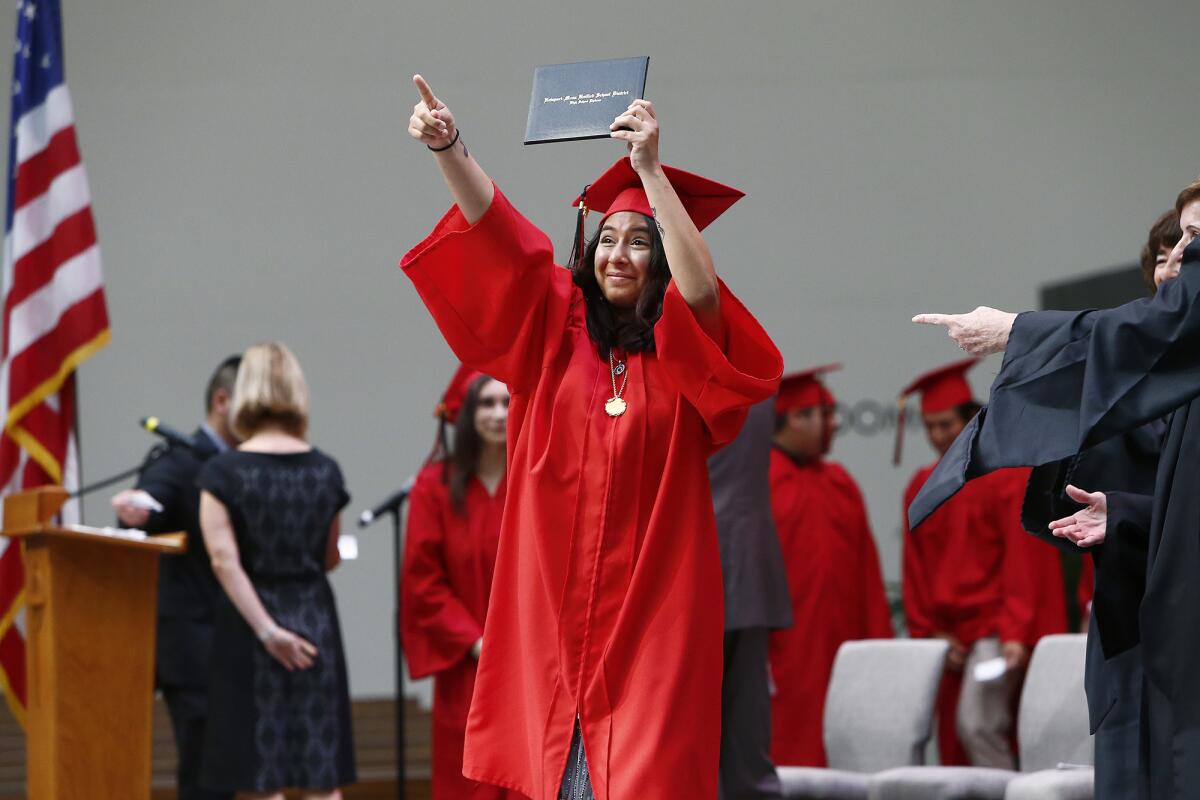 Back Bay High's Cheila Fuentes acknowledges teachers after receiving her diploma.