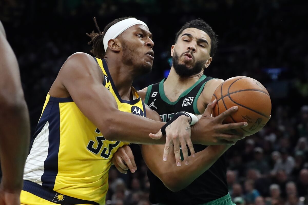 Indiana Pacers' Myles Turner (33) drives for the basket against Boston Celtics' Jayson Tatum during the second half of an NBA basketball game Friday, March 24, 2023, in Boston. (AP Photo/Michael Dwyer)