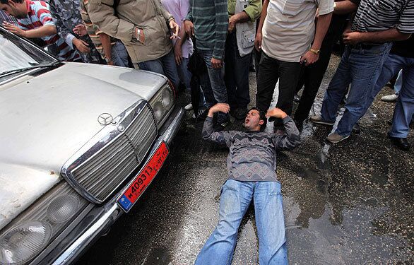 A Lebanese taxi driver lies on the ground as he defies an operating cab during a strike for taxi and bus drivers who are protesting rising petrol prices in Beirut.