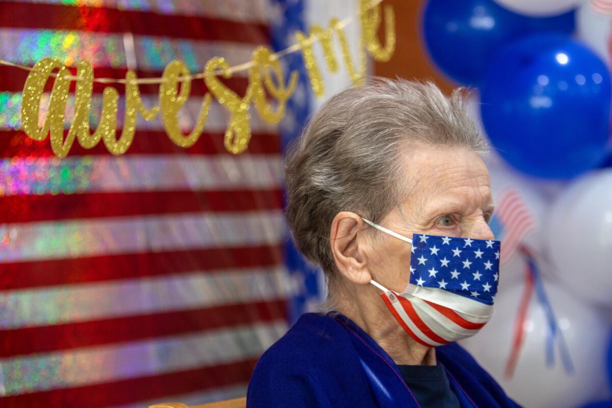 A closeup of a woman with a flag face mask. 