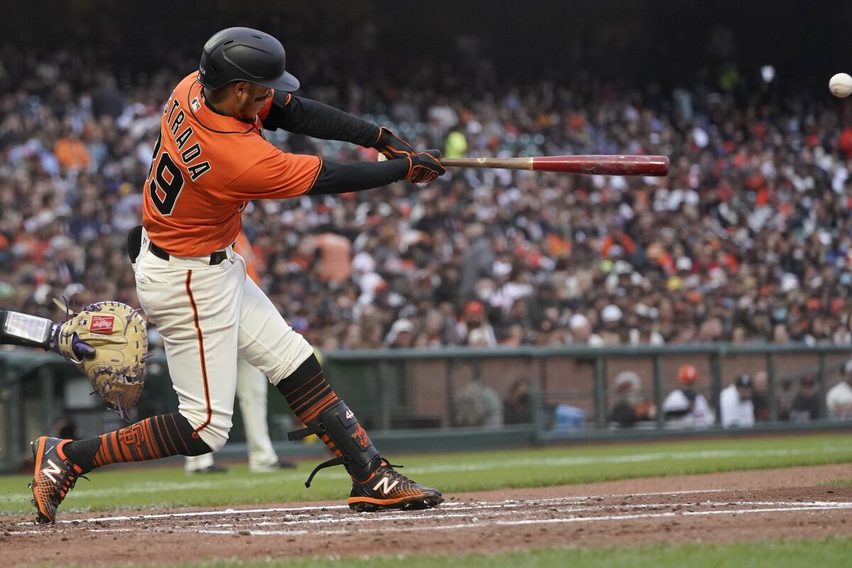 San Francisco Giants' Thairo Estrada hits an RBI-single against the Colorado Rockies during the first inning of a baseball game in San Francisco, Friday, Aug. 13, 2021. (AP Photo/Jeff Chiu)