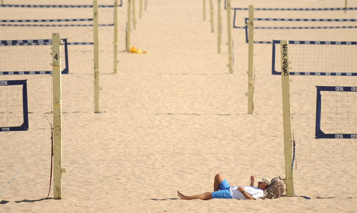 Frank Kaiser of Lawndale relaxes among the beach volleyball courts in Manhattan Beach on Aug. 28.