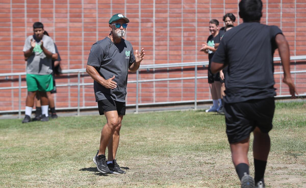 Tom Hatch works with the freshman football team during summer practice at Costa Mesa High School Tuesday.