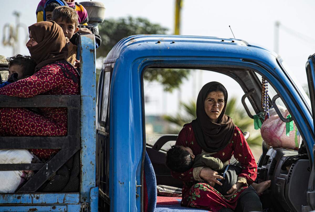 Syrian families flee the battle zone between Turkey-led forces and Kurdish fighters Oct. 15 in Ras al-Ayn.