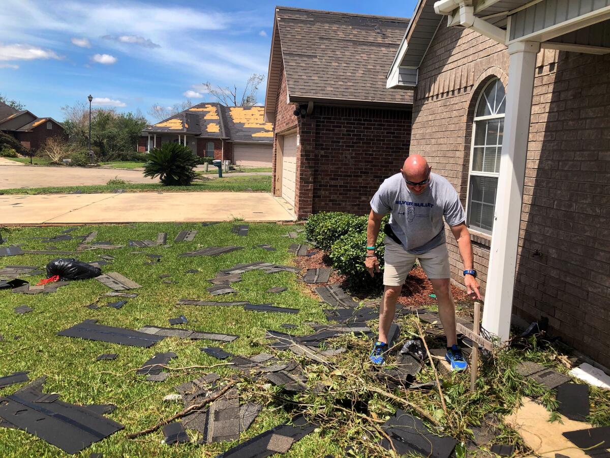 Kevin Richard  cleans up in front of his home in Lake Charles, La.