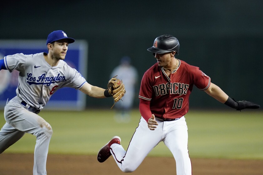 El campocorto de los Dodgers, Tree Turner, a la izquierda, marcando a Josh Rojas de Arizona durante la octava entrada.