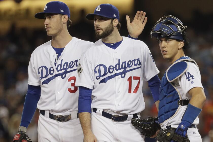 Dodgers reliever Brandon Morrow receives a pat on the back from Cody Bellinger as he waits for manager Dave Roberts to pull him from the game in the sixth inning.
