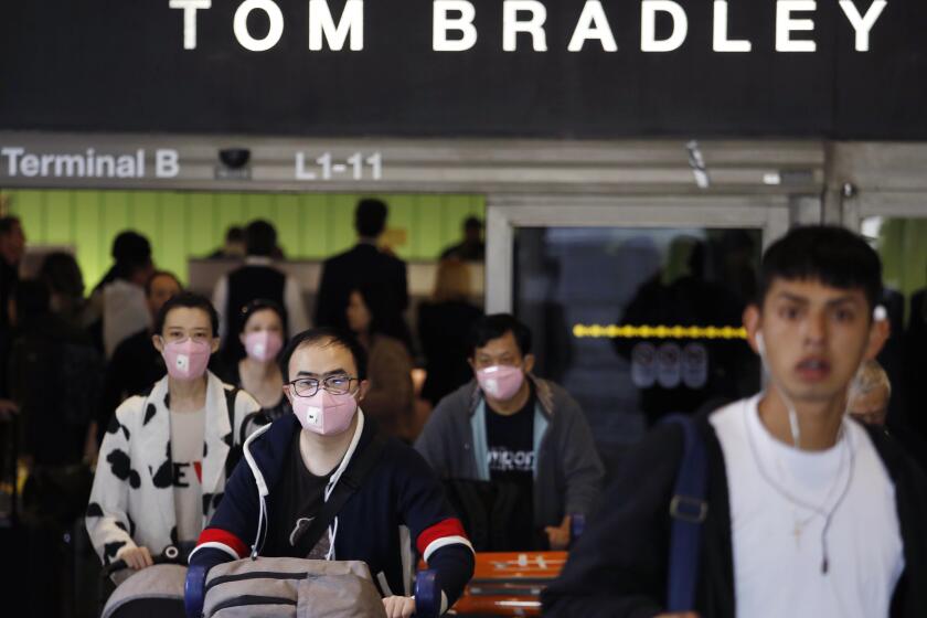 LOS ANGELES CA - FEBRUARY 8, 2020 - Some travelers wear masks in fear of the coronavirus while arriving at the Tom Bradley International Terminal at Los Angeles International Airport in Los Angeles on February 8, 2020. (Genaro Molina / Los Angeles Times)