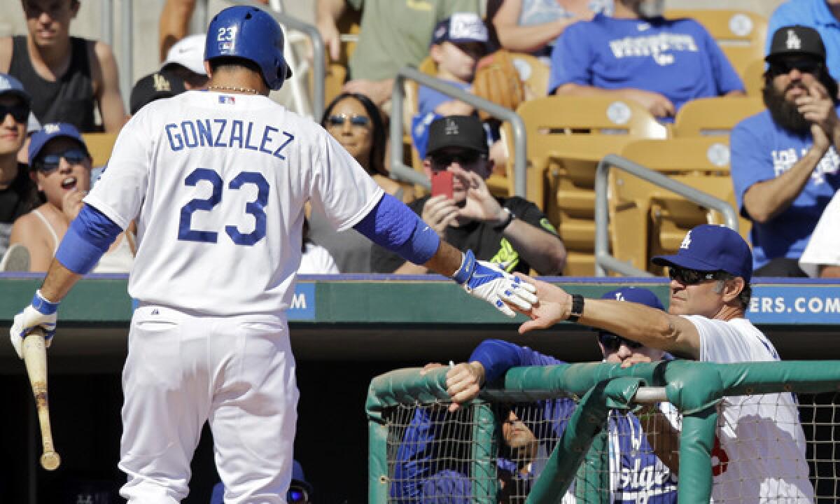 Dodgers first baseman Adrian Gonzalez, left, is congratulated by Manager Don Mattingly after driving in a run on a sacrifice fly during the fifth inning of Sunday's Cactus League game against the Colorado Rockies.