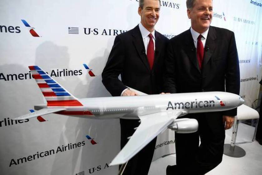 American Airlines CEO Tom Horton, left, and US Airways CEO Doug Parker appear with an airplane model bearing the new American Airlines logo after announcing the two airlines' merger at Dallas-Fort Worth International Airport.