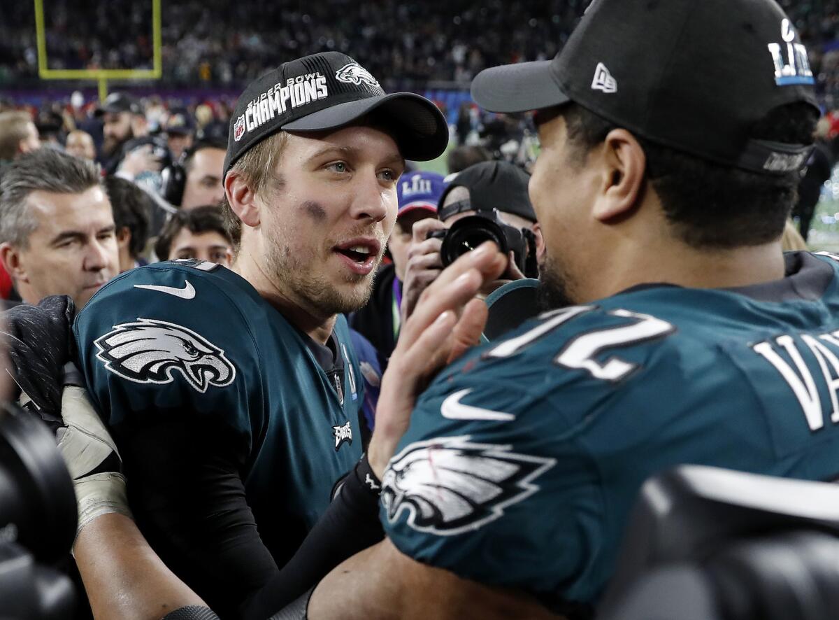 Eagles quarterback Nick Foles, left, celebrates with teammate Halapoulivaati Vaitai after defeating the Patriots.